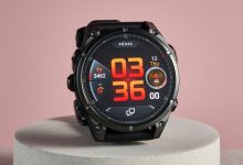 Đồng hồ Garmin Fēnix màu đen đặt trên bục nền hồng.