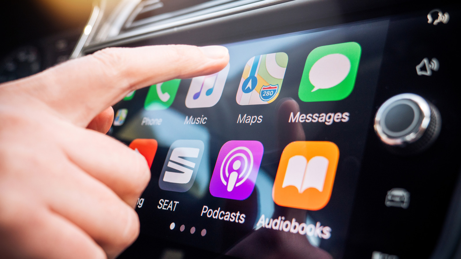 Người dùng chạm vào màn hình Apple CarPlay trong xe