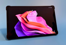 Lenovo Legion Tab Gen 5 đặt ngang trong bao gập màu đen, màn hình khóa hồng tím hiển thị 12:30 trên nền xanh.