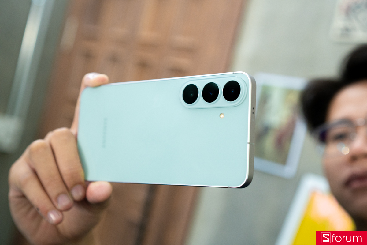 Galaxy S26 FE màu xanh được cầm trên tay, thấy rõ cụm ba camera sau