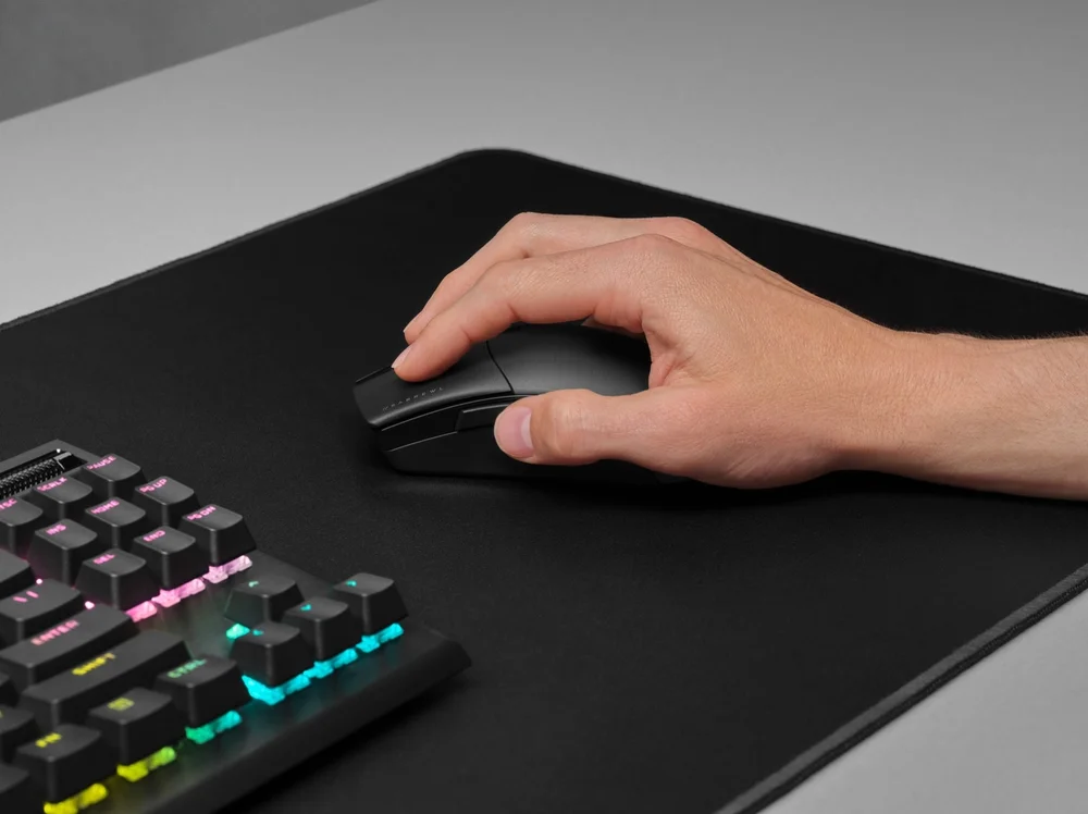 Bàn tay sử dụng chuột gaming trên mousepad trong bối cảnh chơi game thực tế; hình minh họa cho việc đánh giá form và độ thoải mái thay vì chỉ nhìn thông số. Ảnh: Corsair.