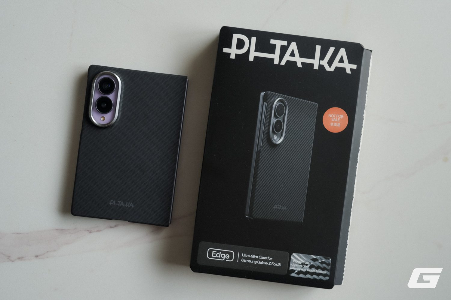 Galaxy Z Fold8 gắn ốp PITAKA Edge Case vân sợi đặt cạnh hộp sản phẩm Edge.