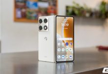 Razr Fold mở hình chữ V, thấy mặt lưng trắng, cụm camera và màn hình ngoài đang bật.