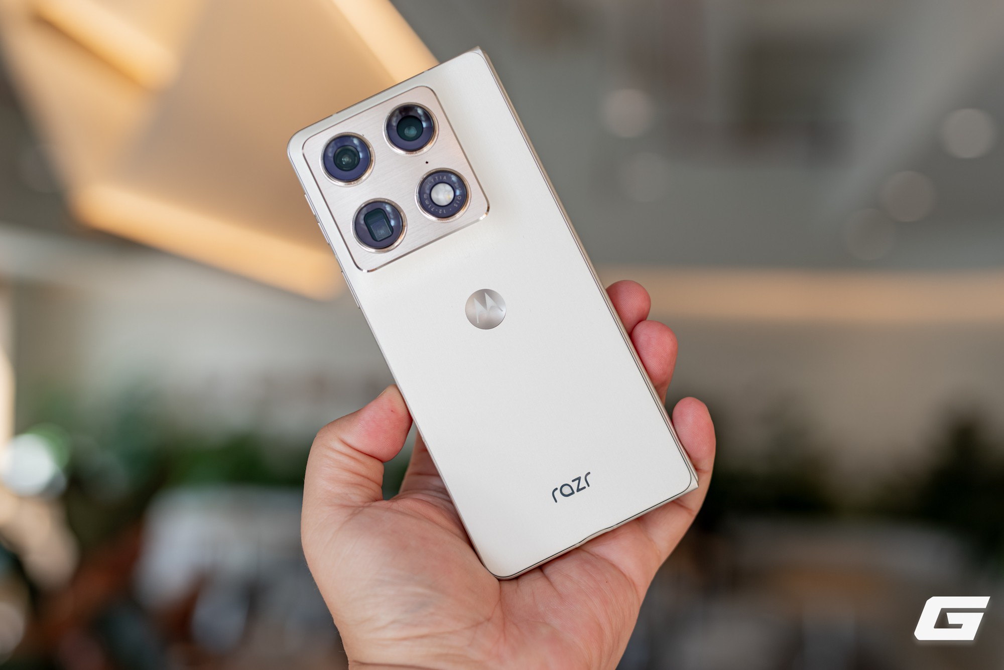 Người dùng cầm Razr Fold gập lại, nhấn vào mặt lưng và cụm camera sau.