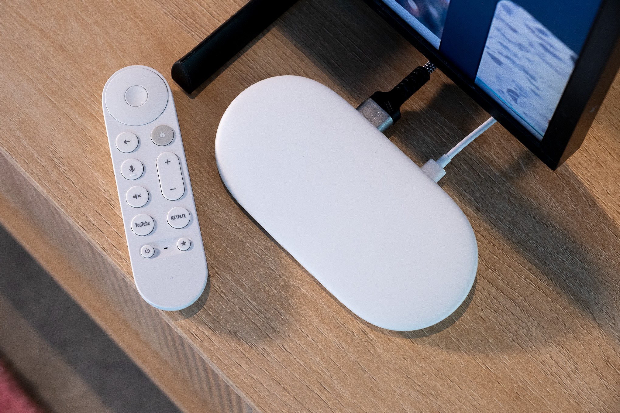 Google TV Streamer đặt trên mặt bàn trong ảnh chụp thực tế.