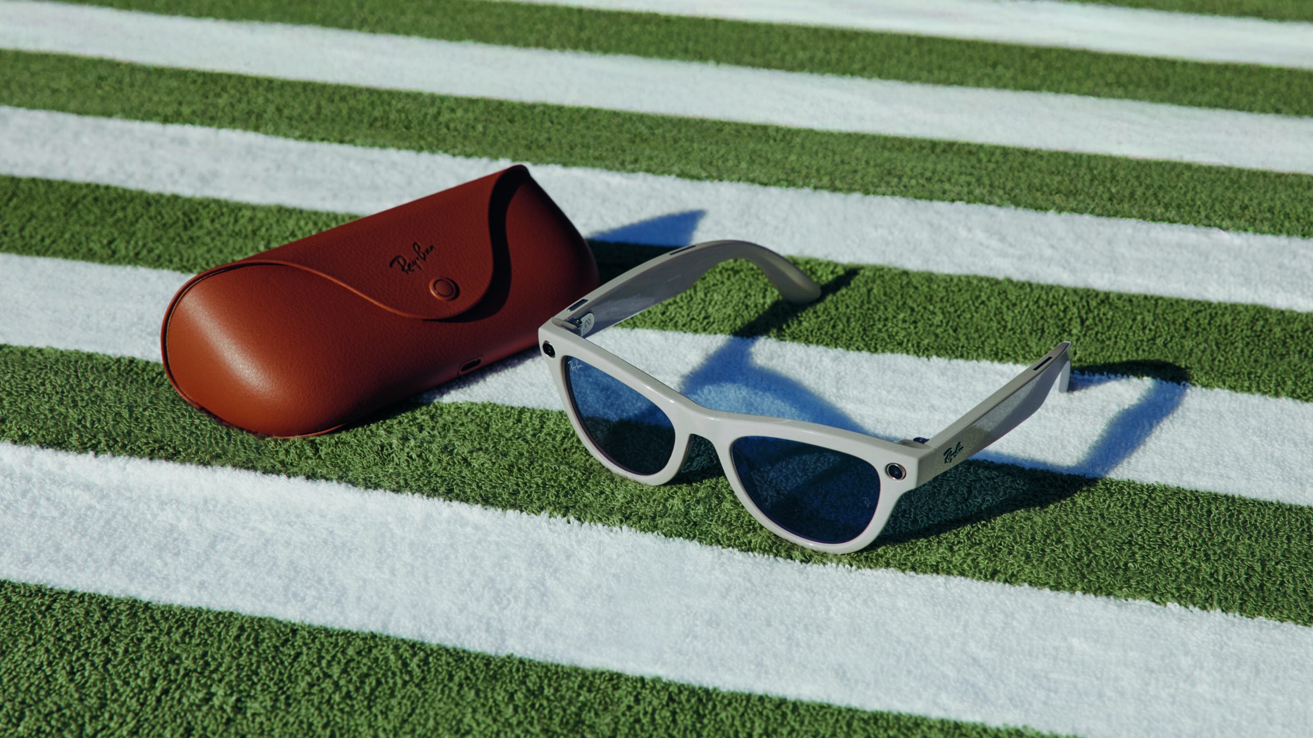 Kính Ray-Ban Meta màu trắng đặt cạnh hộp đựng màu nâu.