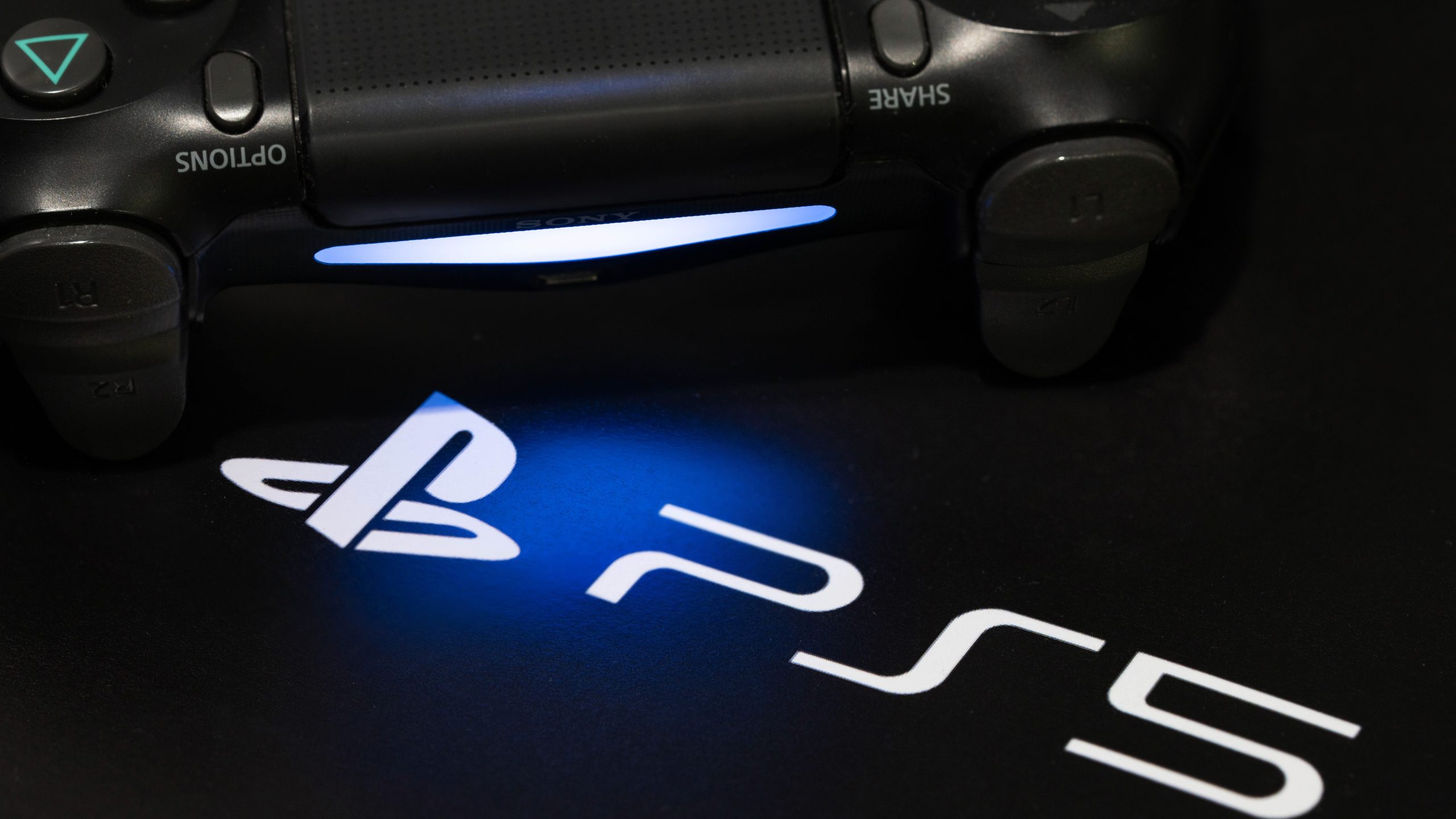 Logo PlayStation 5 và tay cầm điều khiển trên nền đen
