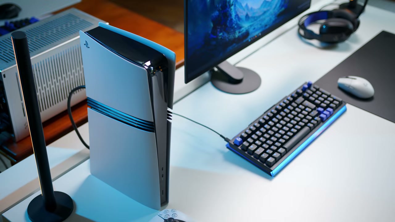 Góc bàn làm việc với PS5 Pro, màn hình và bàn phím cơ