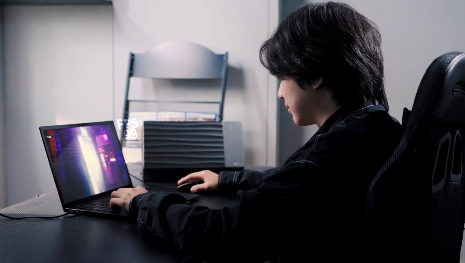 Người dùng laptop chơi game với chỉ báo FPS trên màn hình.