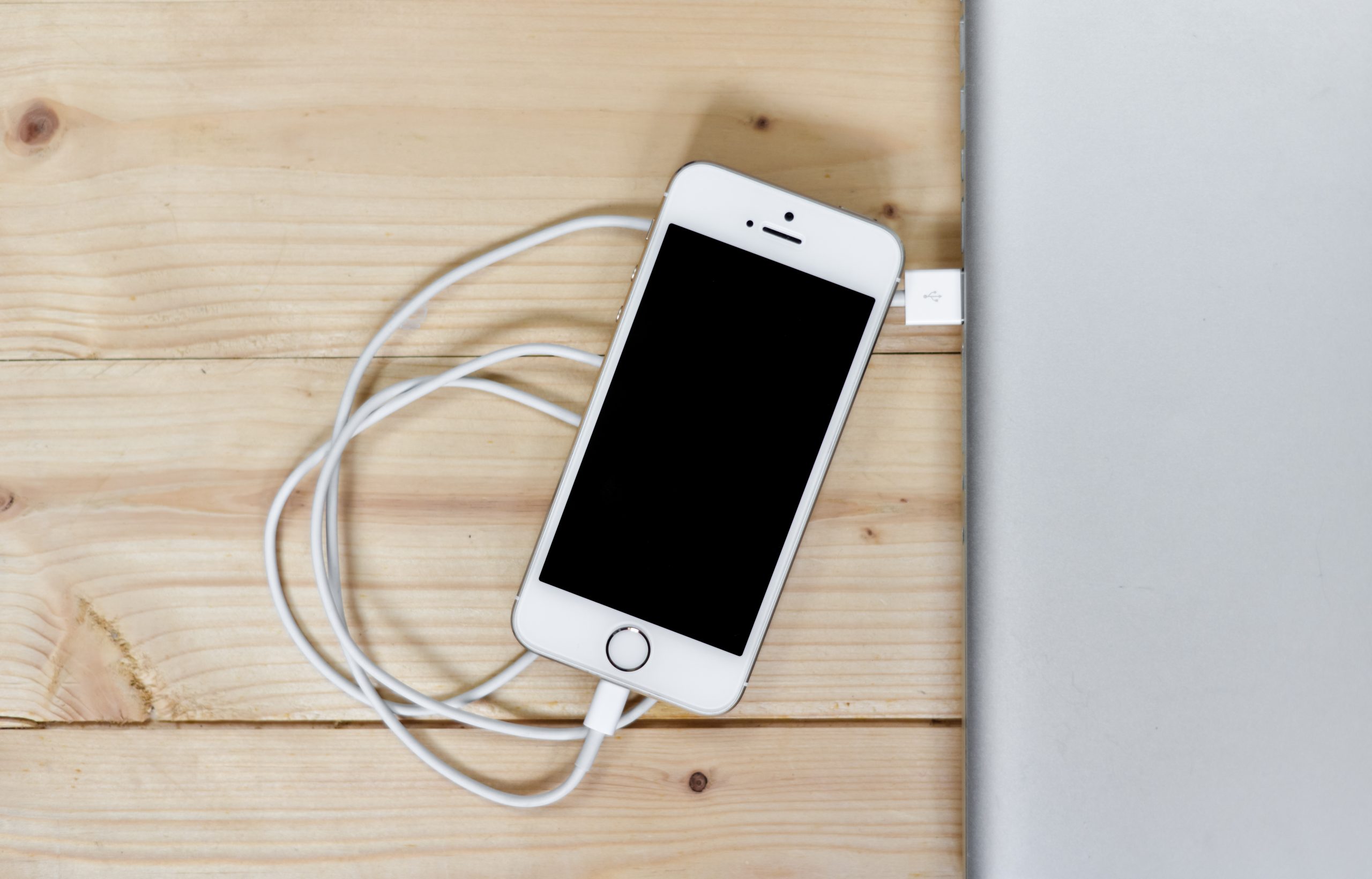 Chiếc iPhone đặt trên mặt bàn làm việc bên cạnh sổ ghi chép