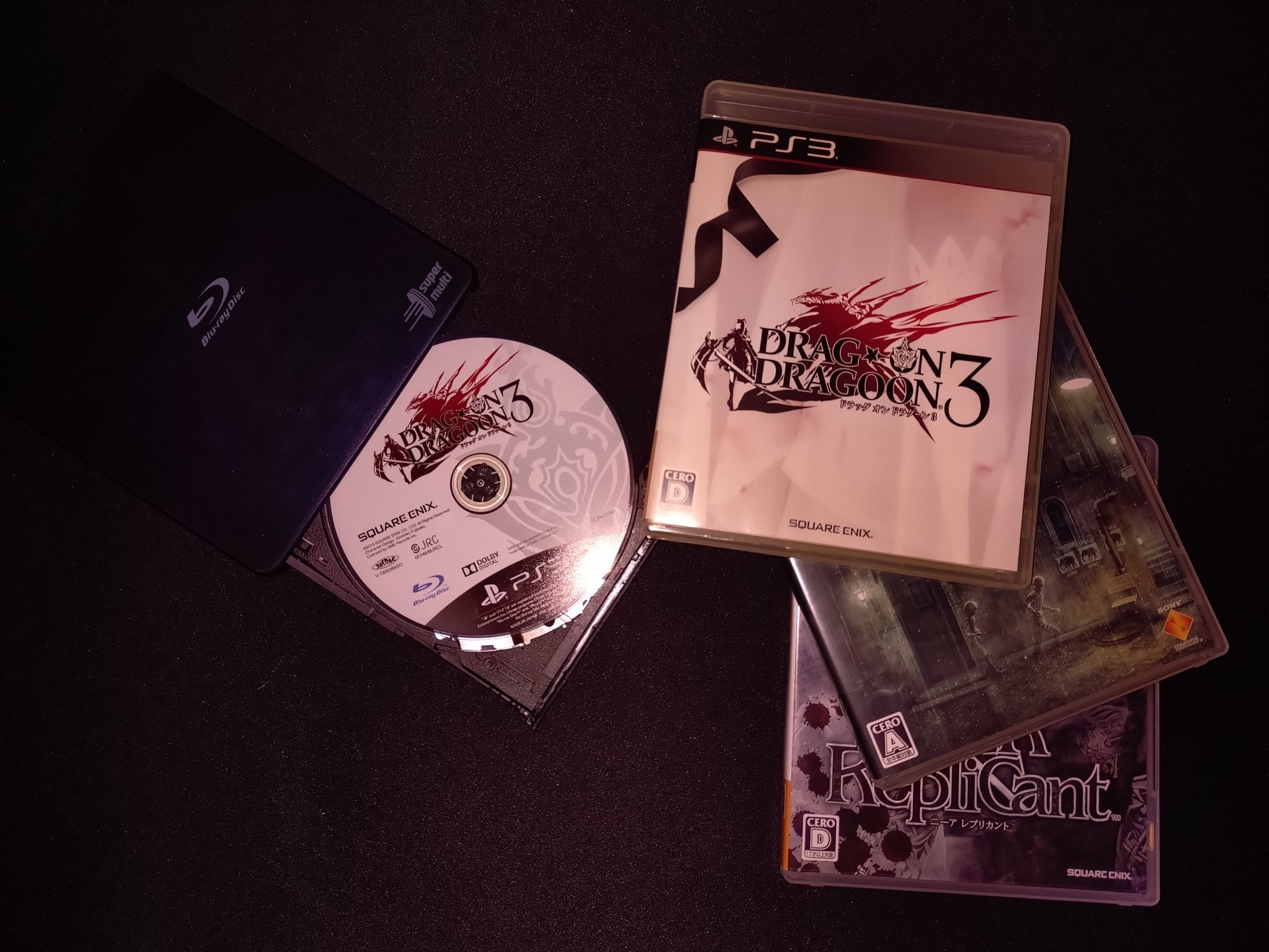 Ổ đĩa Blu-ray và đĩa game PS3 đặt cạnh máy tính