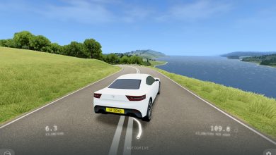 Một chiếc xe màu trắng đang chạy trên đường ven hồ trong game Slow Roads