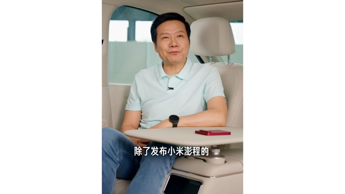 Lei Jun ngoi trong xe, may Xiaomi 18 Fold mau do dat tren ban ke ghe sau