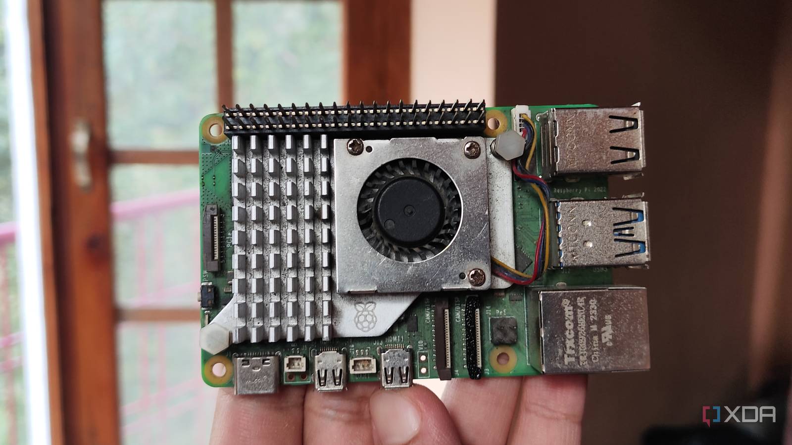A person holding a Raspberry Pi 5 — Nguồn: XDA Developers