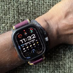 Apple Watch Ultra 4 trên cổ tay với dây màu đỏ tím
