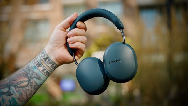 Blue Agave Sonos Ace Ultra headphones being held outdoors