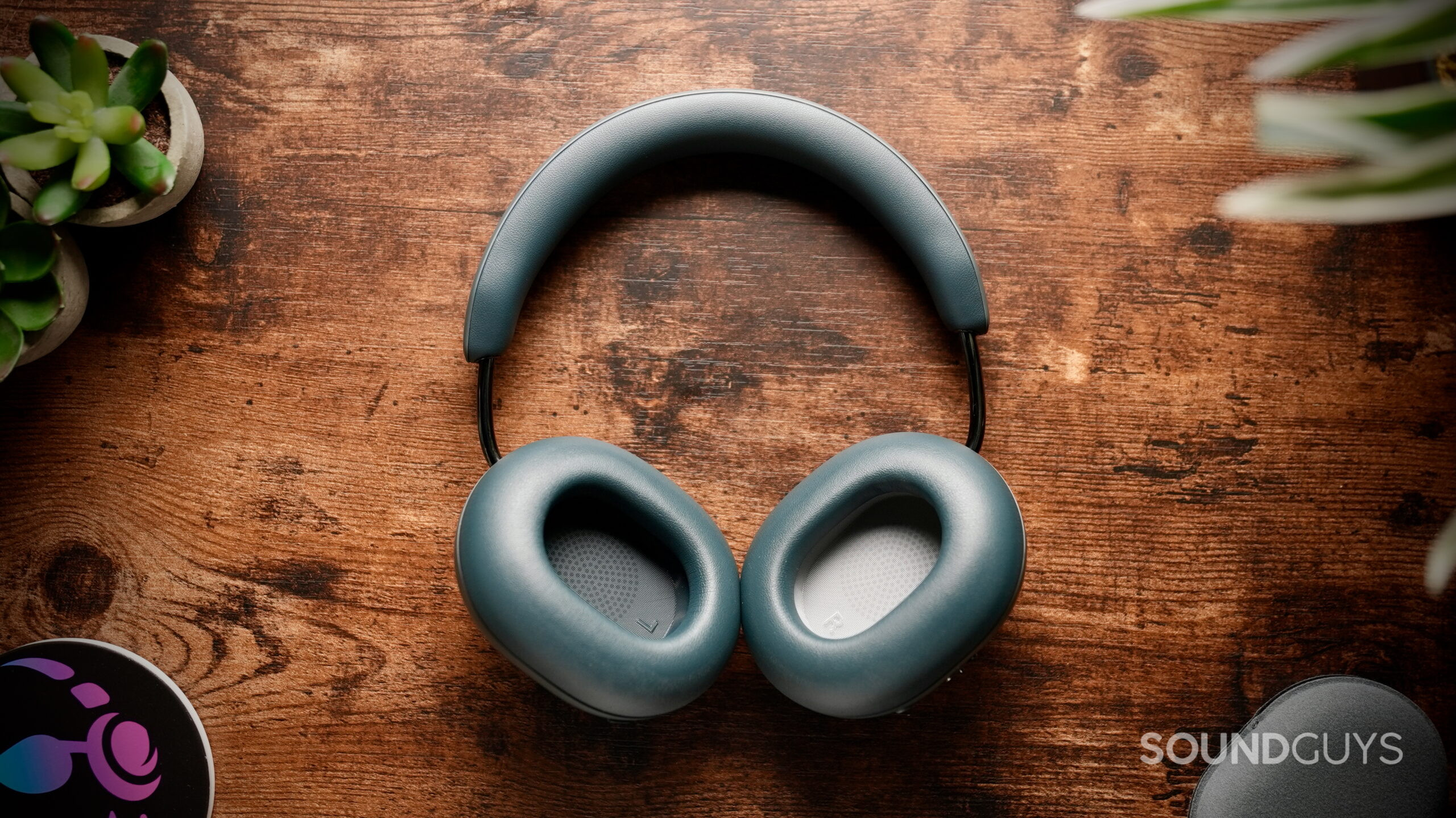 Blue Agave Sonos Ace Ultra headphones lying on a wooden table.