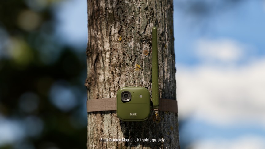 Camera Blink Frontier XR+ màu xanh gắn vào thân cây bằng dây đai.