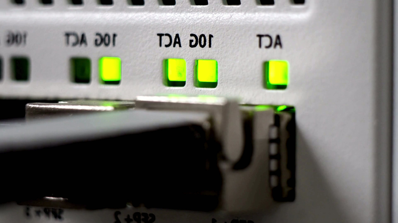 Cáp Ethernet cắm vào thiết bị mạng với các đèn trạng thái màu xanh.