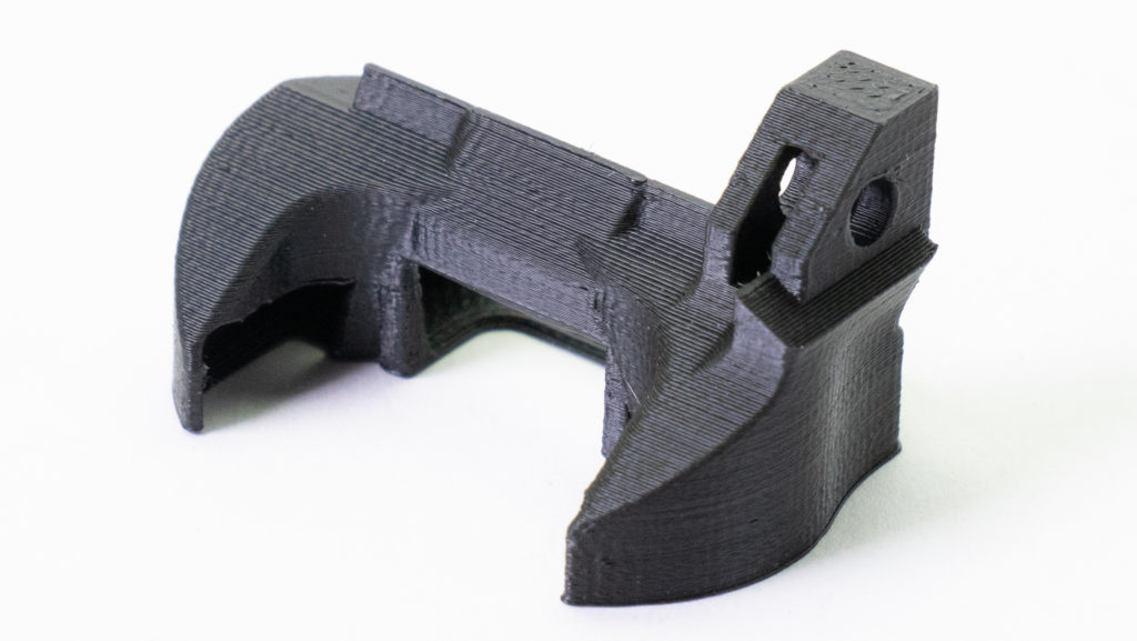 Chi tiết kẹp in 3D màu xám đặt trên nền trắng