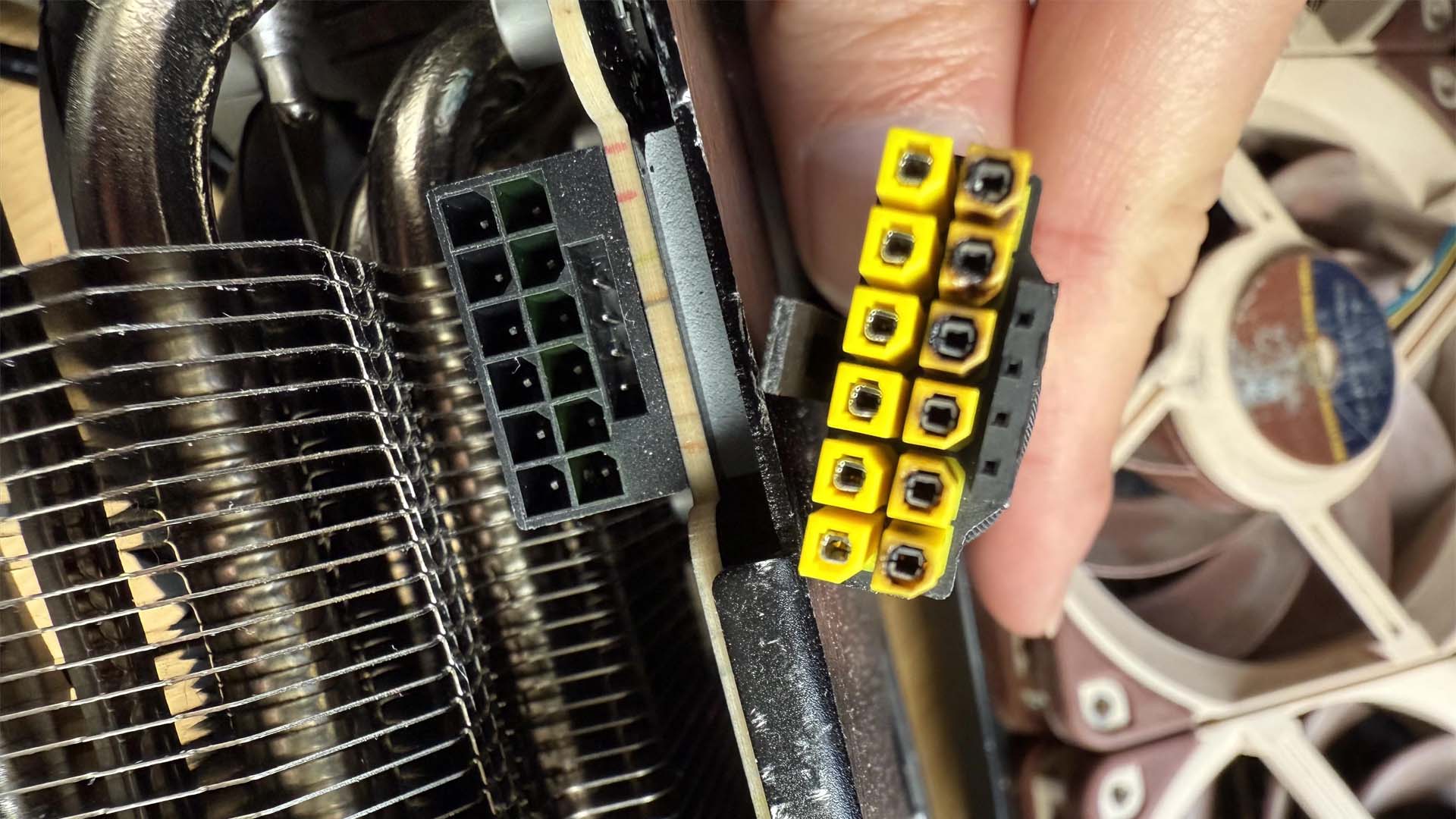 Đầu nối nguồn 16-pin có phần nhựa ngả màu và dấu hiệu cháy cạnh ổ cắm.