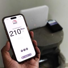 Điện thoại chạy bài kiểm tra tốc độ đặt cạnh gateway Wi-Fi
