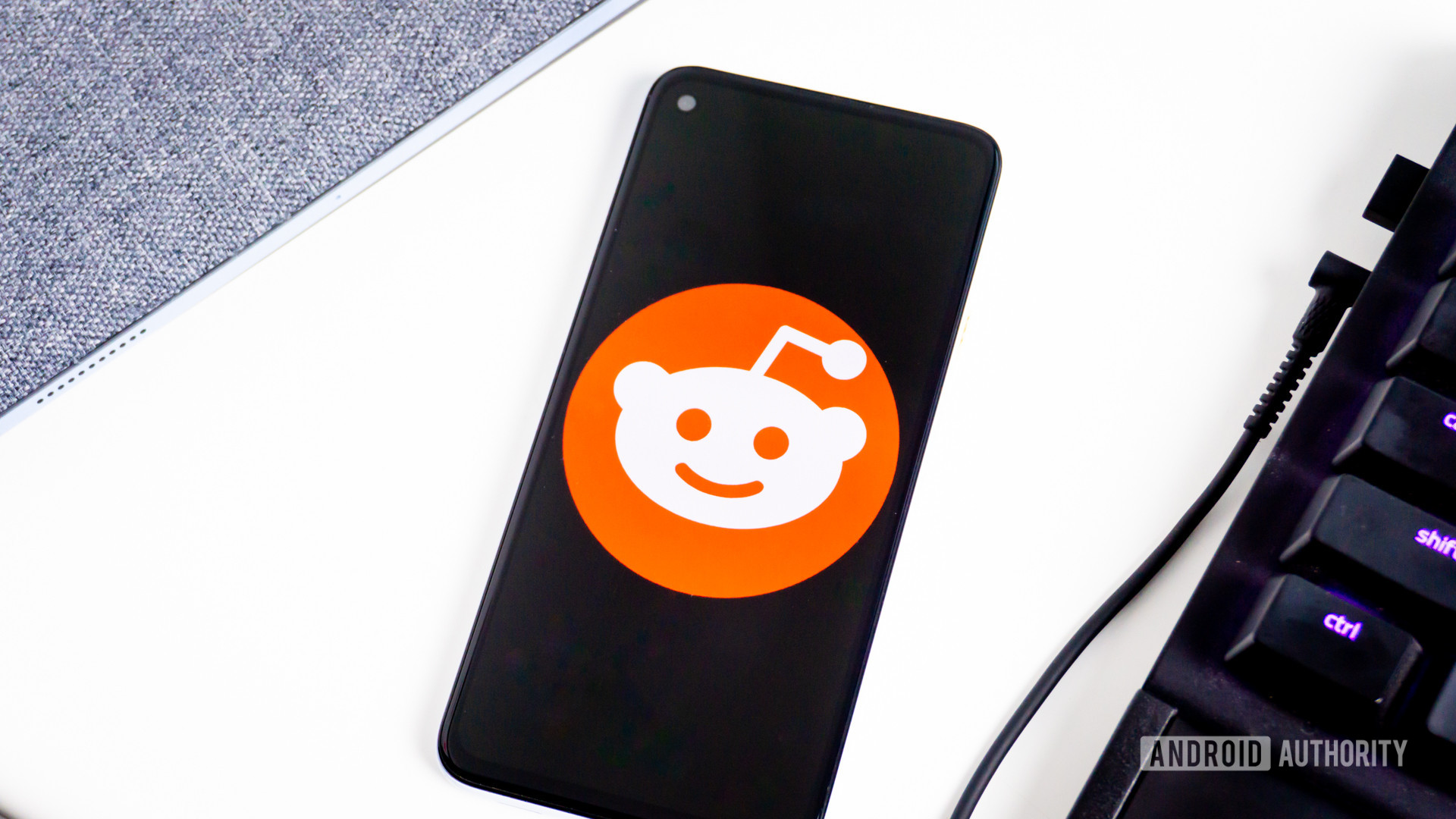 Điện thoại hiển thị biểu tượng Reddit cạnh bàn phím