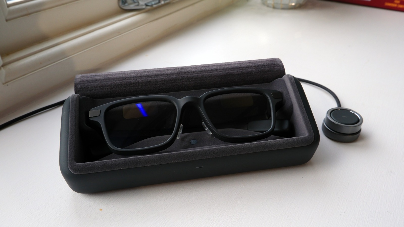Even Realities G2 trong hộp sạc với màn hình hiển thị sáng