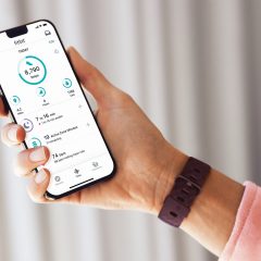 Fitbit Charge 4 đặt cạnh ứng dụng Fitbit trên điện thoại