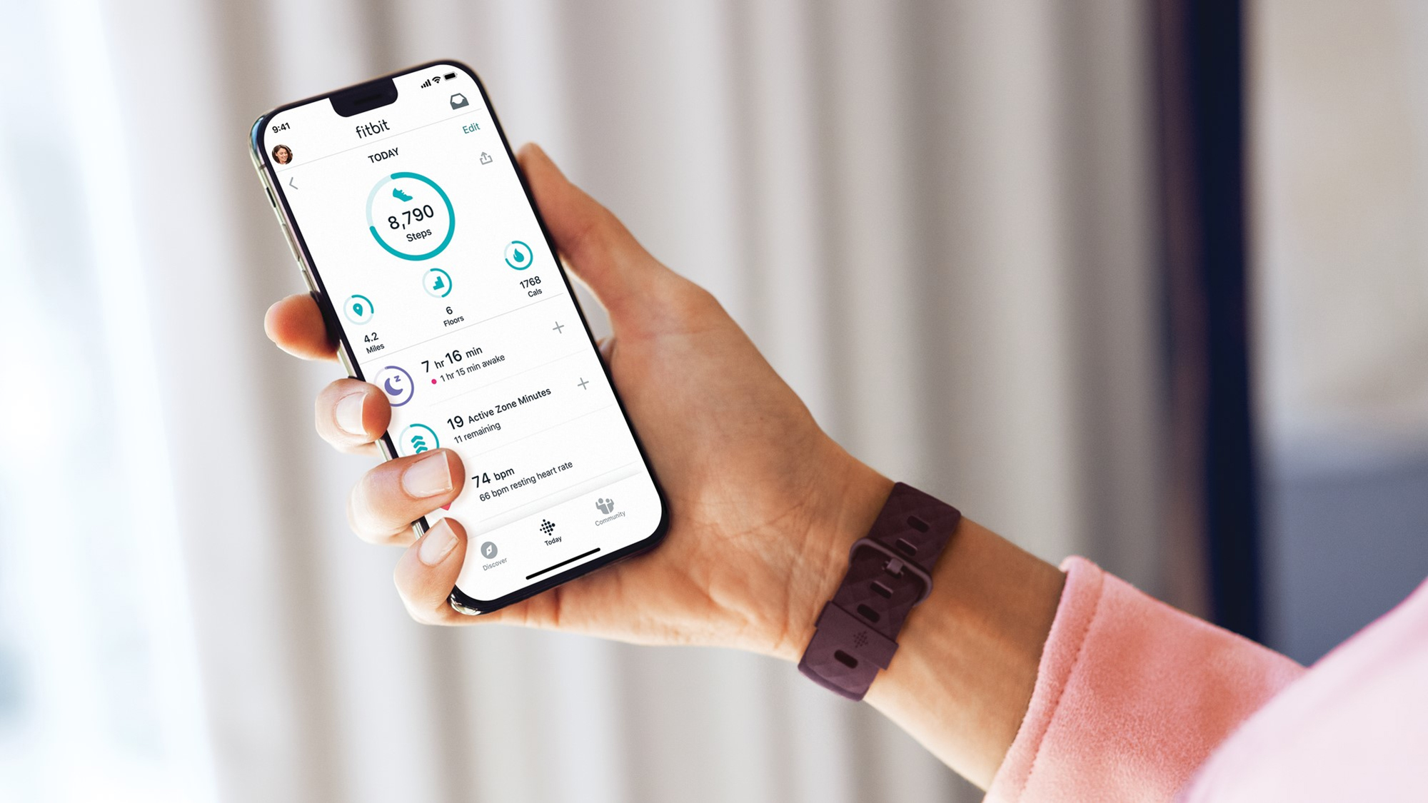 Fitbit Charge 4 đặt cạnh ứng dụng Fitbit trên điện thoại