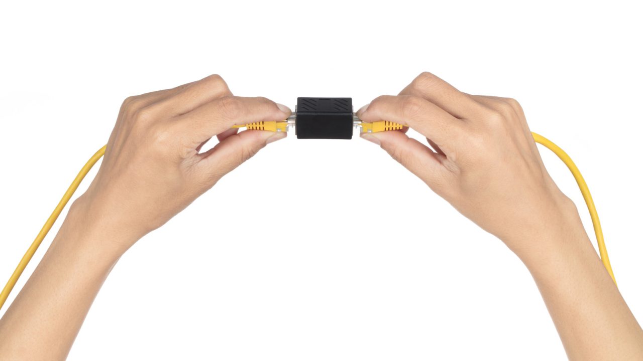 Hai đầu cáp Ethernet màu vàng được ghép bằng coupler RJ45 màu đen.