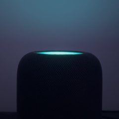 HomePod mini phát sáng màu xanh trên mặt cảm ứng trong phòng tối