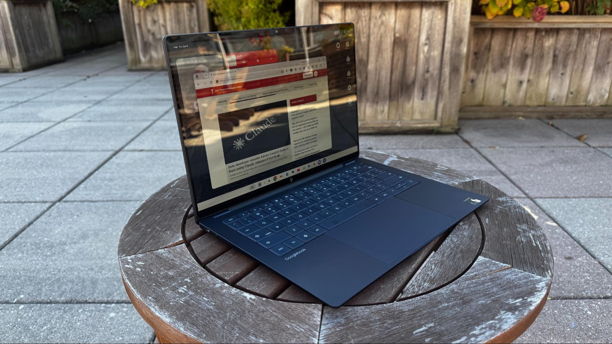 HP Googlebook 14 đặt trên bàn ngoài trời, màn hình mở với Chrome và bàn phím đầy đủ.