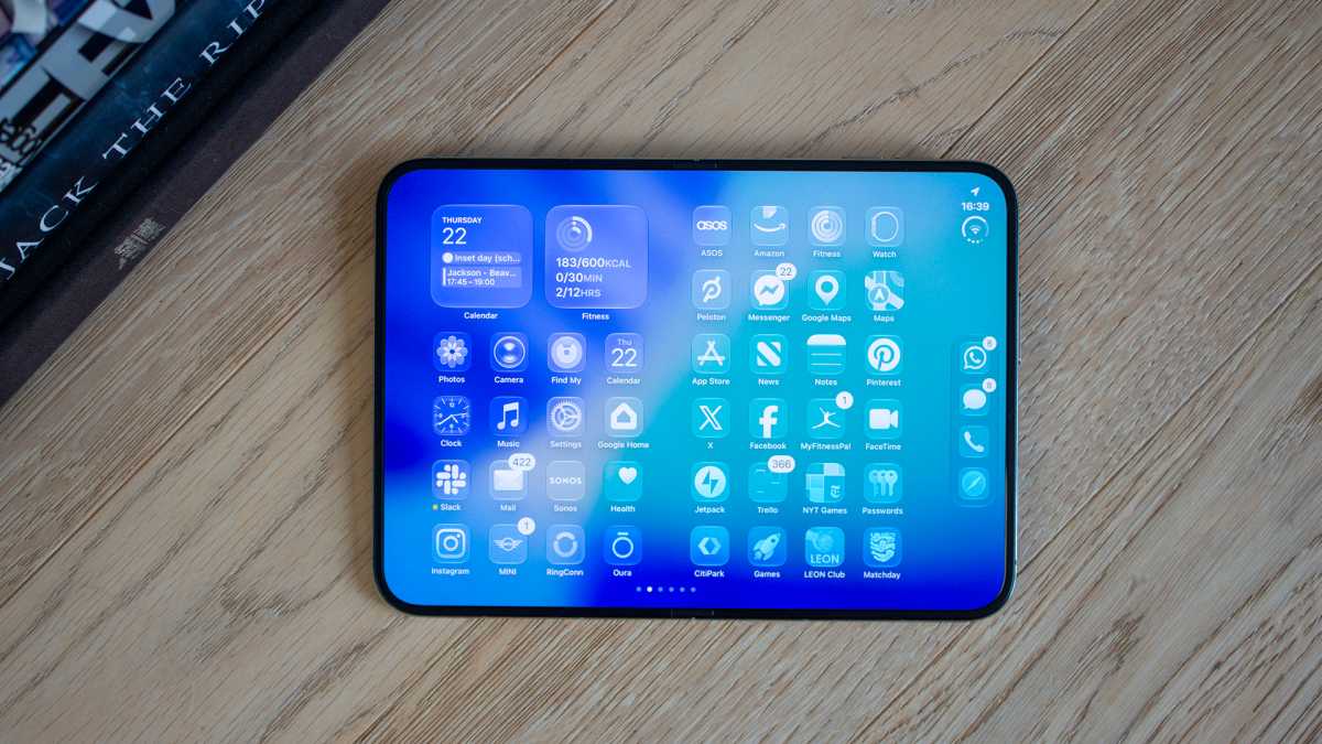 iPhone Duo mở phẳng trên bàn gỗ, màn hình trong hiển thị thư viện ứng dụng