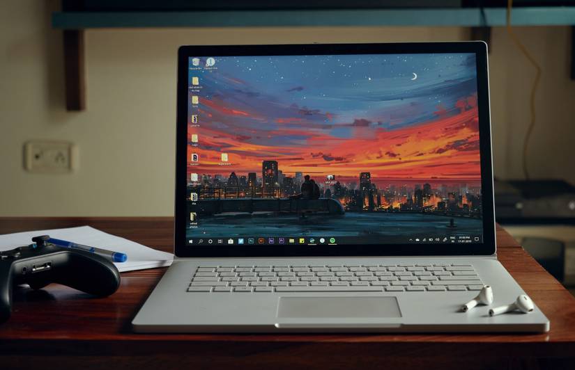 Laptop vỏ sò đang bật màn hình đặt trên bàn