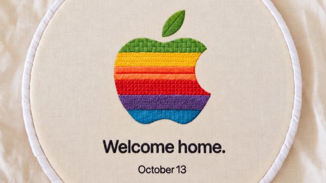 Logo Apple nhiều màu được khâu trên nền vải cùng dòng chữ Welcome home và October 13