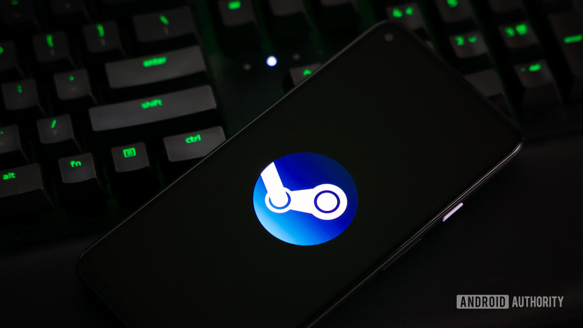 Logo Steam trên màn hình điện thoại cạnh bàn phím máy tính