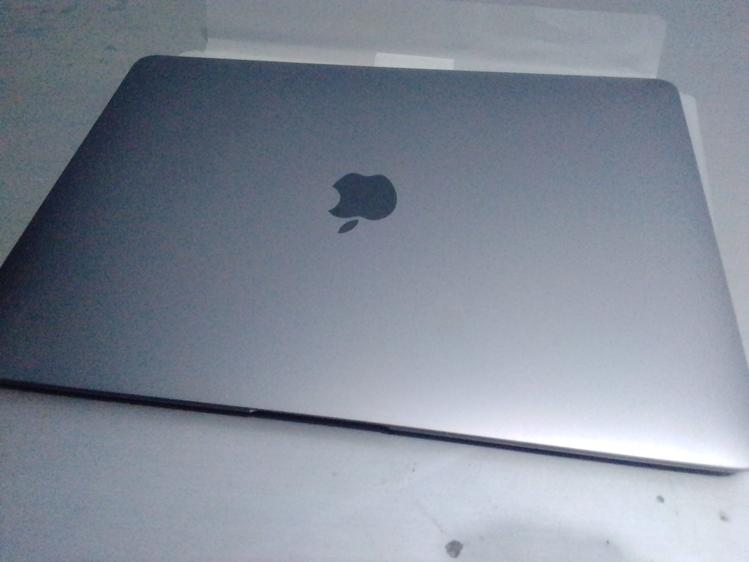 Mặt lưng MacBook Air màu bạc có logo Apple.
