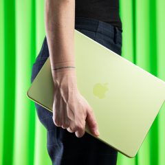 MacBook Neo màu xanh cầm bên mình