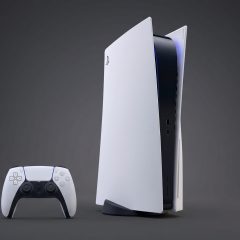Máy chơi game PlayStation 5 đặt đứng cạnh tay cầm DualSense trên nền tối.