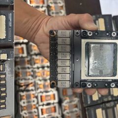 Mô-đun NVIDIA Tesla V100 SXM2 được cầm trên tay giữa nhiều mô-đun tương tự