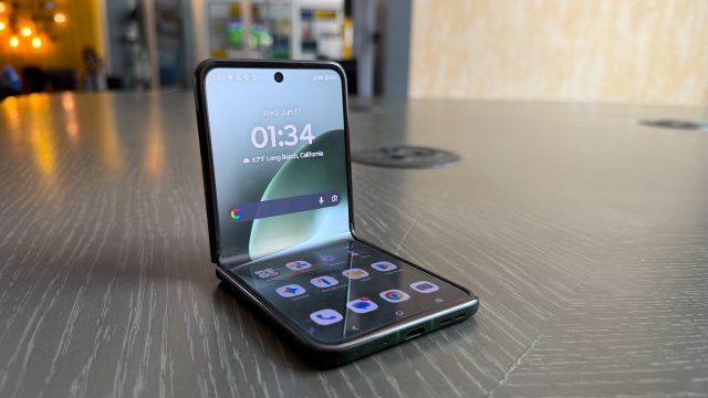 Motorola Razr+ 2026 gập nửa đặt trên bàn, màn hình hiển thị giờ và biểu tượng ứng dụng
