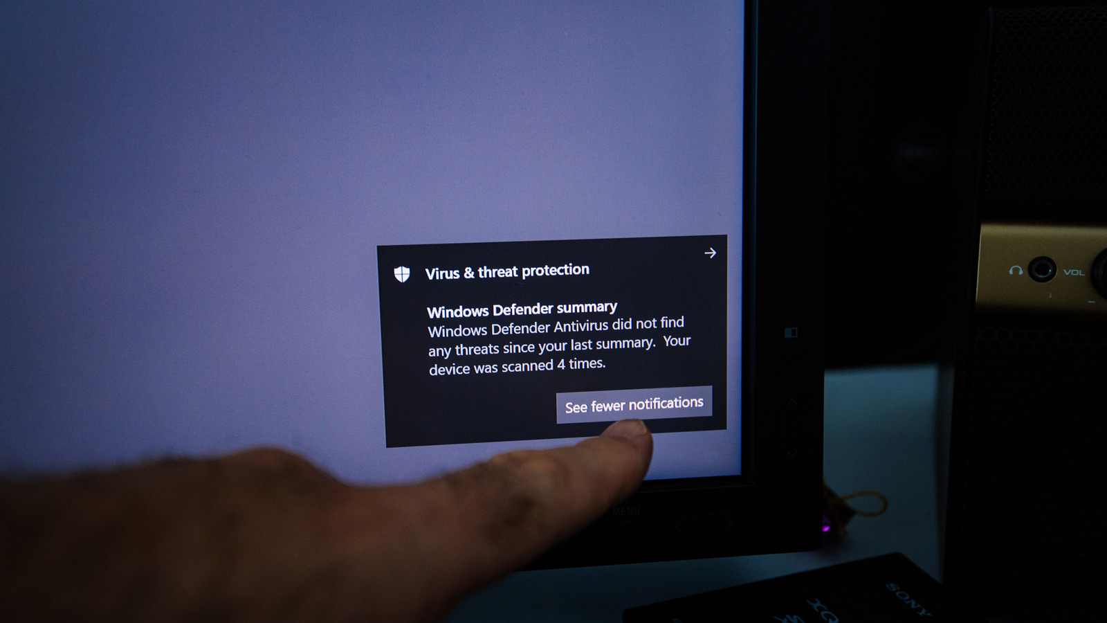 Ngón tay chỉ vào thông báo Windows Defender trên màn hình Windows 10