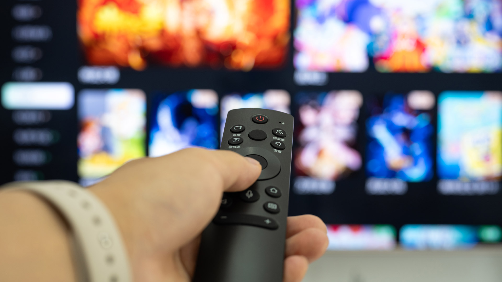 Người dùng cầm điều khiển trước màn hình TV
