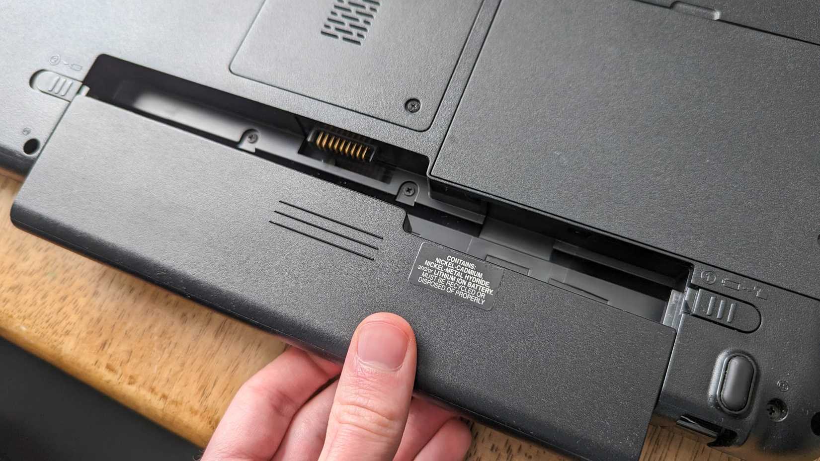 Người dùng mở laptop để tiếp cận pin bên trong
