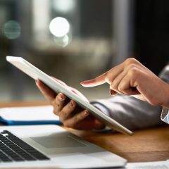 Nhân viên sử dụng máy tính xách tay và máy tính bảng tại bàn làm việc