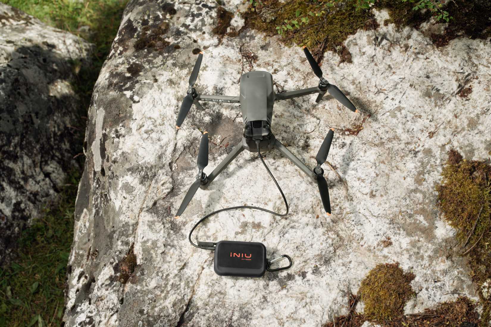 Pin INIU Rugged Series sạc drone trên tảng đá
