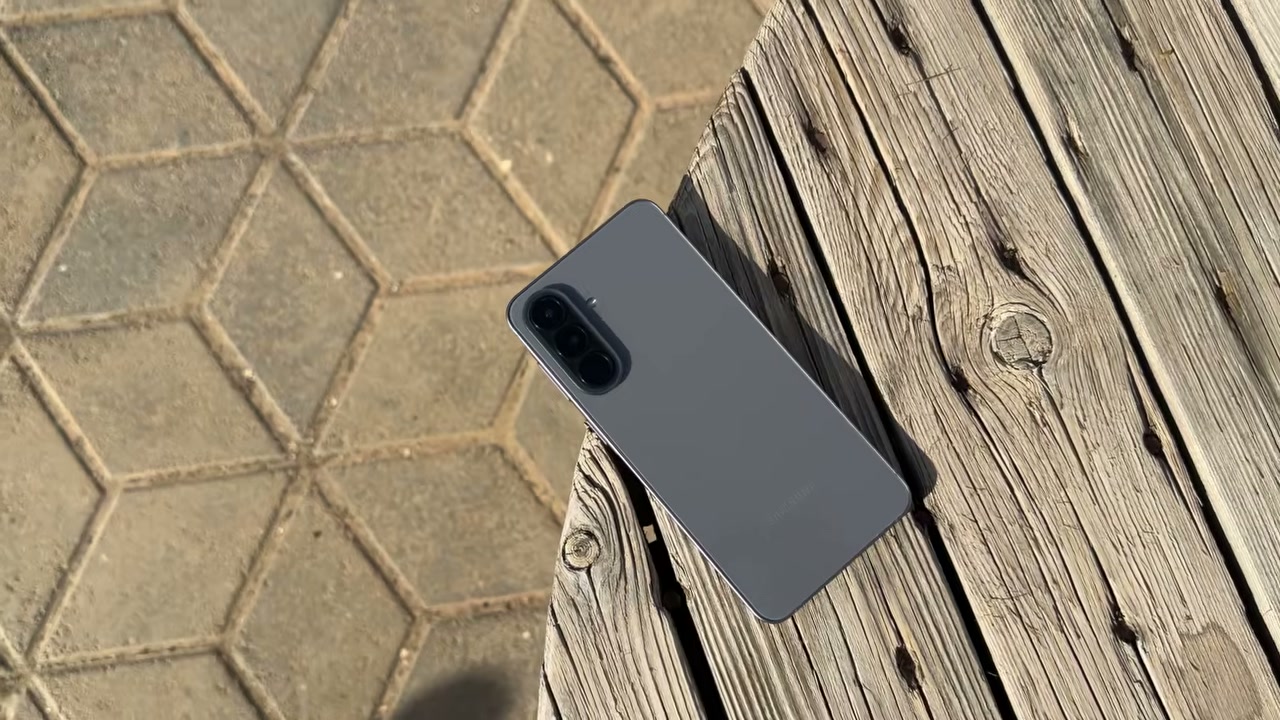 Samsung Galaxy A57 màu xám đặt trên băng ghế gỗ