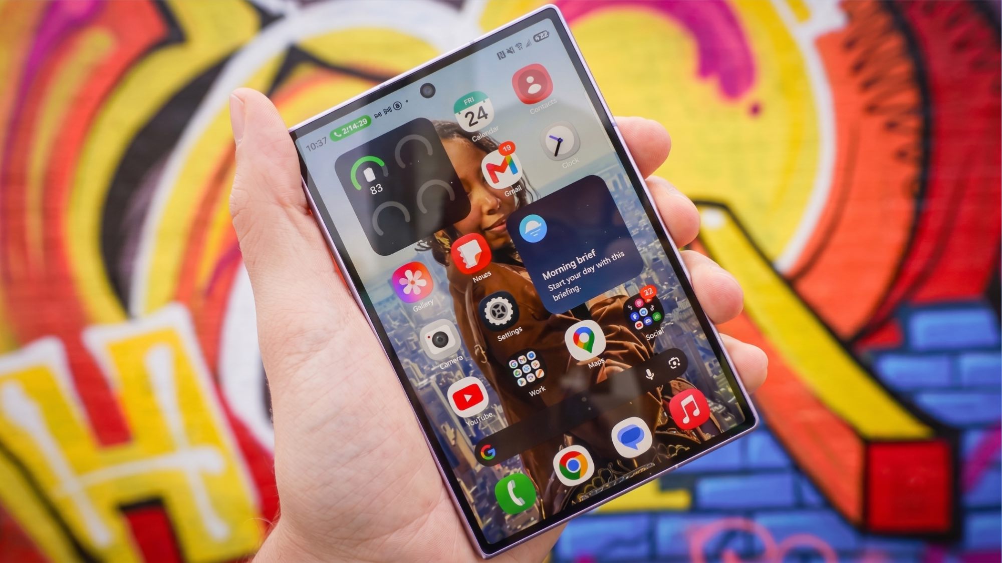 Samsung Galaxy Z Fold 8 in hand showing cover display against a wall with graffiti