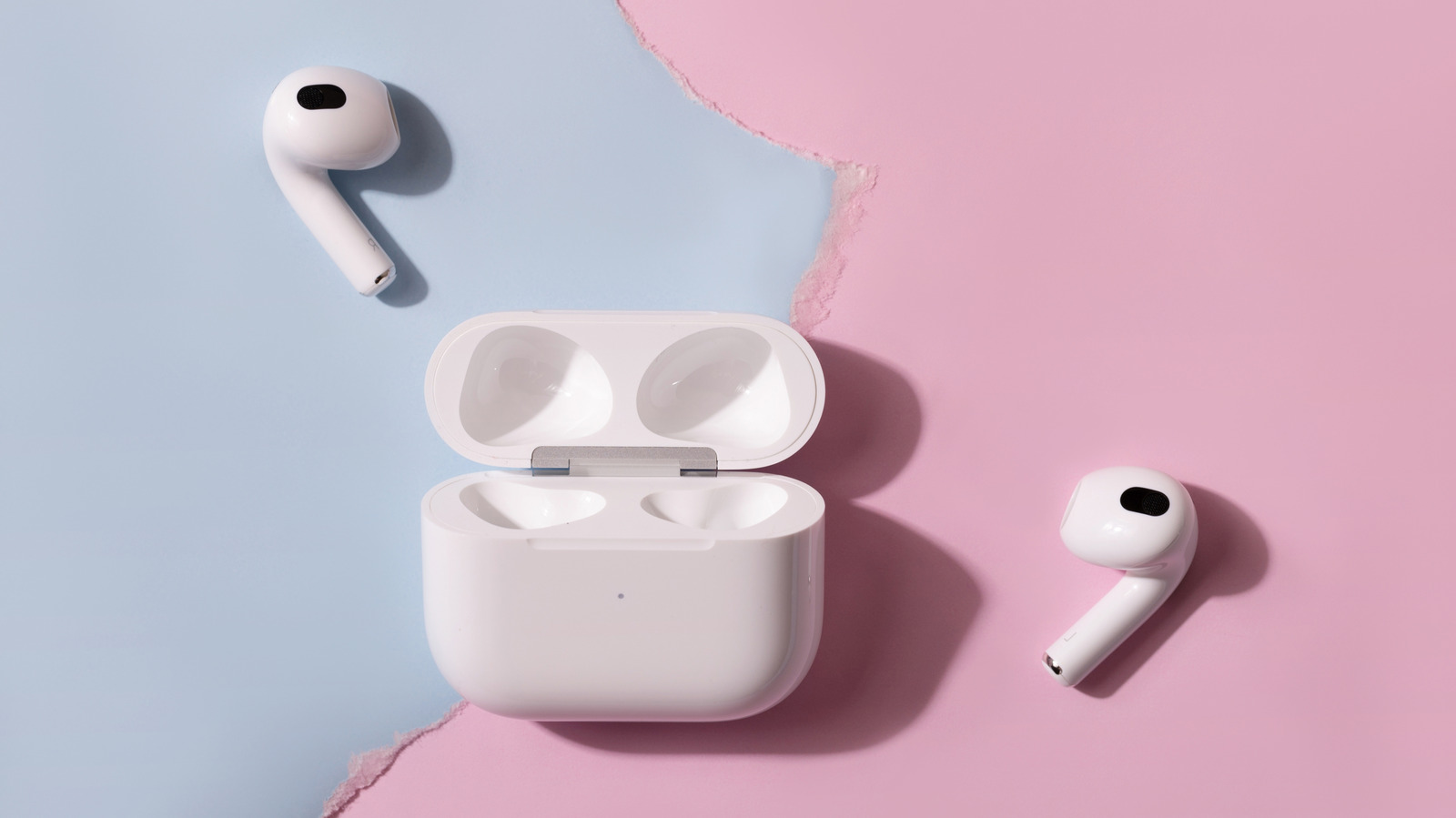 Tai nghe AirPods và hộp sạc mở nắp trên nền hồng xanh